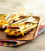 Sliced eggplant with anchovies, gruyère and peppers