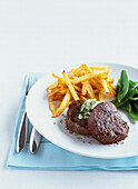 Beef fillets with french fries and sugar peas