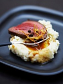 Slice of roast beef with mashed potatoes and ginger flavored butter