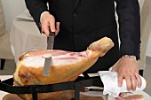 Carving a raw ham on a ham stand