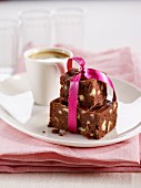 Brownie mit rosa Schleife und Tasse Kaffee