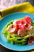 Scallops with rose petals on a bed of zucchinis