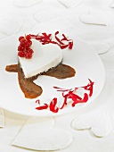 Heart-shaped cream dessert with dark chocolate sauce