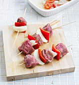 Raw veal skewers with onions and peppers