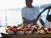 Peppers and cheese on sliced bread :appetizers on a boat