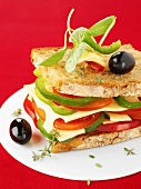Sandwich mit Paprika, Tomaten, Käse und Oliven
