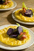mini omelettes served with purple potatoes, diced bacon and dandelions