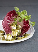 Small mozzarella balls with crushed pistachios in a red chicory leaf