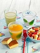 Vegetable milk, orange juice, fruit salad and cake for a kid's breakfast
