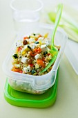 Quinoa-Feta-Salat im Plastikbehälter zum Mitnehmen