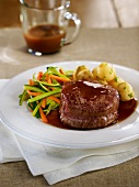 Tournedos with gravy, Pommes Dauphine and sliced vegetables