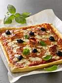 Hausgemachte Pizza mit Schinken, Käse und Oliven