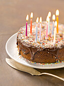 Schokoladenkuchen mit brennenden Geburtstagskerzen