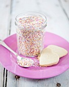 Jar of multicolored sugar drops and shortbread cookies