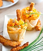 Small crisp carrot bites and chicken fingers coated in crushed hazelnuts and parmesan