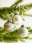 Silberne Christbaumkugeln hängen am Weihnachtsbaum