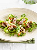 Asian-style beef, cucumber and pepper in lettuce leaves
