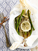 Catfish with capers and green asparagus cooked in wax paper