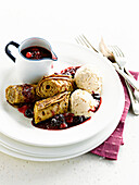 Rolled pancakes with stewed summer fruit and nougat ice cream