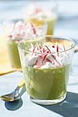 Cream of pea soup with salty whipped cream and thinly chopped radishes