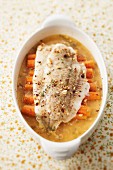 Halibut with crushed hazelnuts and carrots in thyme broth