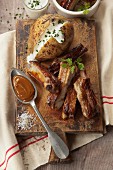 Pork spare ribs with baked potato in it's jacket with cream and chives