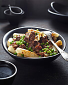 Beef ragout with peas over noodles