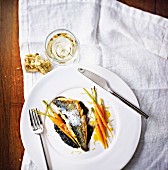 Sea bass fillets with onions, smoked milk, squid ink cream and carrots with orange