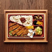 Bento Box mit Katsu Hühnchen, Gemüse, Reis und Obst