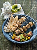 Marinated chicken,bay leaf and thyme brochettes,pitta bread and multicolored tomato salad