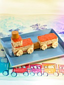 Kids' sandwich in train shape with crackers, sausages, pepper cream and mayonnaise