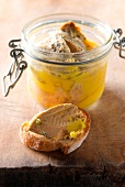Foie Gras im Einmachglas und auf einer Scheibe Baguette