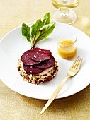 Fresh goat's cheese coated in crushed hazelnuts and topped with thinly sliced beetroot