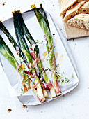 Steamed leeks wrapped in bacon with honey