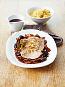 Sliced roast pork with prunes,onions and thinly sliced almonds