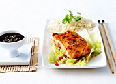 Glazed piece of salmon with soya sauce and red chili peppers