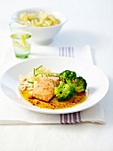 Piece of salmon in chili sauce, steamed broccolis and farfalle