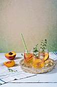 Sangria mit Pfirsich und Thymian in Gläsern
