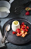 Panna cotta with passion fruit puree and fresh fruit salad