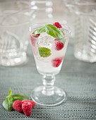 Glass of lemonade with raspberries and basil