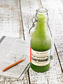 Apple and spinach smoothie with mint in a bottle