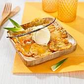 Thin slices of caramelized pineapple and a scoop of vanilla ice cream