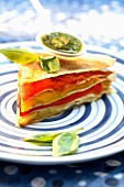 Slice of stewed red and yellow pepper,pesto and filo pastry layer