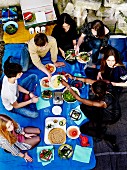 Bunch of teenagers picnicking outdoors