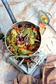 Saucepan of stewed artichokes and vegetables