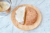 Osterhasen-Kuchen zubereiten: Kuchenhälfte mit Zuckerguss bestreichen