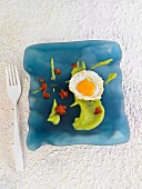 A fried egg with guacamole and red tapenade