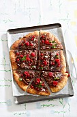 A sweet pizza with chocolate, redcurrants, raspberries and mint