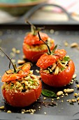 Stuffed tomatoes topped with crushed pine nuts and basil