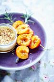 Apricot brochettes and apricot cream with crushed hazelnuts